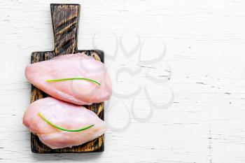 raw chicken breast fillet on cutting wooden board