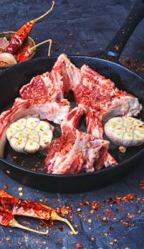 raw meat on the rib of lamb in hot spices on pan