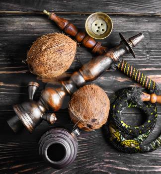 Stylish Oriental hookah and ripe tropical coconut