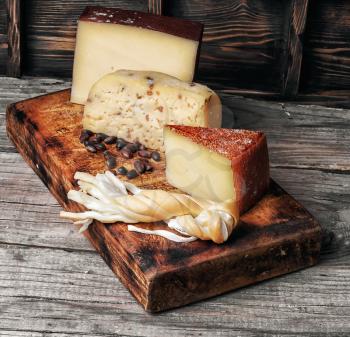 Four varieties of delicious homemade cheese on the kitchen board