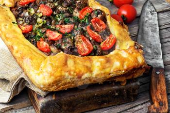 Delicious meat pie stuffed with mushrooms and tomato