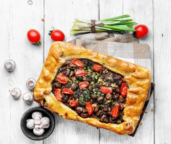Delicious meat pie stuffed with mushrooms and tomato