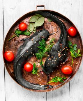 raw fish catfish on copper frying pan