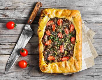 baking meat pie stuffed with mushrooms and tomato