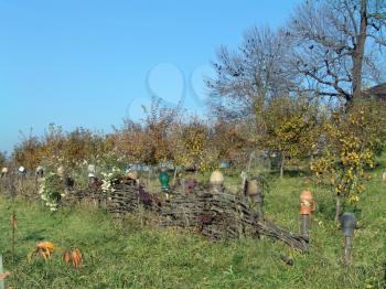 The country old Ukrainian fence, autumn grass and garden