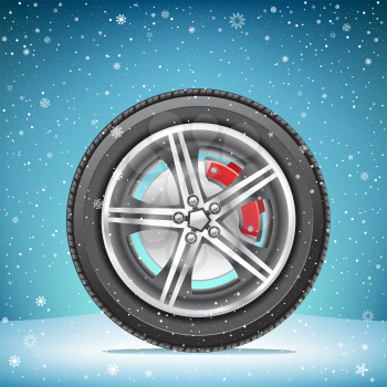 The winter inflated tire on blue snowy background. Wheel in the snow