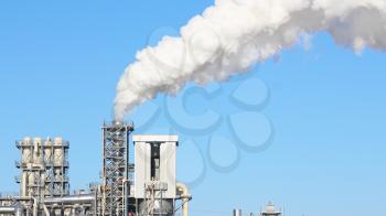 White smoke from the chimney on blue sky background. Industry factory environment ecology pollution