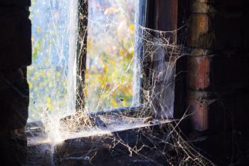 Old window with cobweb around and darkness inside