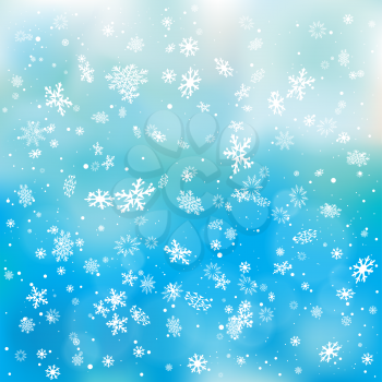 Closeup snowfall on blue sky backdrop. Winter holiday Christmas background. Big and small snowflakes falling from clouds
