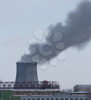 Fuming tube pollutes atmosphere, outdoors shot, industrial building