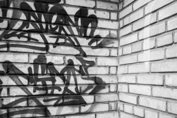 Abstract graffiti fragment on gray brick wall, empty urban interior fragment