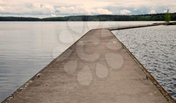 Old concrete pier on calm lake harbor in Imatra town, Finland