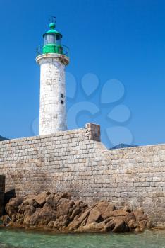 White lighthouse tower on the pier. Entrance to Propriano port, Corsica island, France