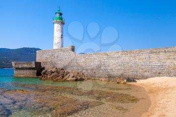 White stone lighthouse tower on the pier. Entrance to Propriano, Corsica island, France