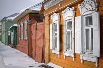 Street with old Russian wooden houses at winter in historical town Kolomna, Moscow Region, Russia
