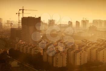 Cityscape of modern Hangzhou city, China. Big living houses under construction at sunrise. Warm tonal correction filter photo effect