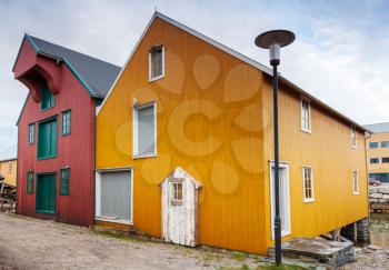 Small town street with red and yellow wooden houses in Norway
