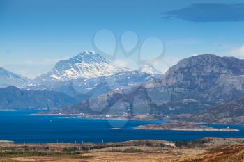 Coastal Norwegian mountain landscape with sea water in fjord