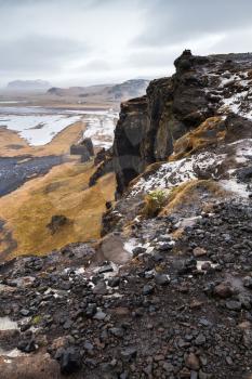Vertical mountain coastal landscape. Black rocks on North Atlantic ocean coast. Dyrholaey Nature Reserve, south coast of Iceland, Europe