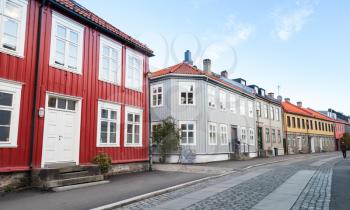 Traditional Scandinavian wooden houses stand along the street in Trondheim, Norway