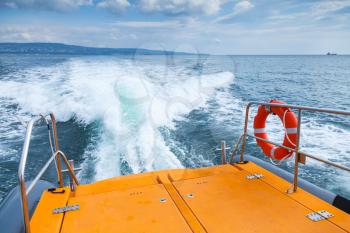 Red lifebuoy hanging on stern railings of fast safety rescue boat