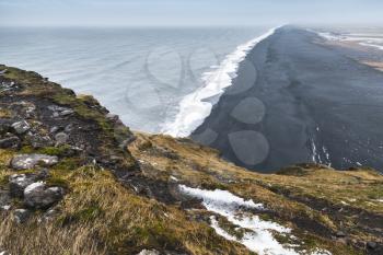 Icelandic coastal landscape. Rocky North Atlantic Ocean coast, black sand beach, Vik district, Iceland