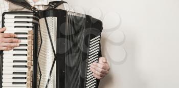 Vintage live music background. Accordionist plays retro accordion. Close-up photo with selective focus