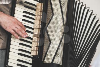 Live music background. Accordionist plays vintage accordion. Close-up photo with selective focus