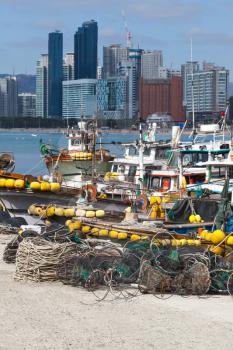 Cityscape of Busan with fishing boats with yellow floats. South Korea