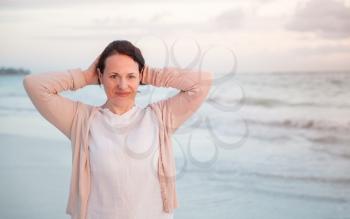 Young Caucasian woman on the ocean coast in early morning, outdoor portrait 