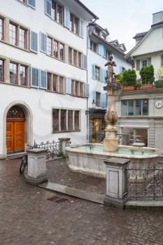 Small square with fountain in old town of Zurich city, Switzerland