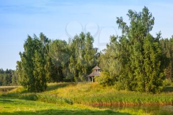 Rural Russian summer landscape with wooden gazebo. Pushkinogorsky District of Pskov Oblast, Russia