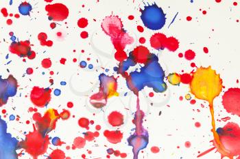 Colorful paint splashes artistic pattern over white paper, background photo texture, top view
