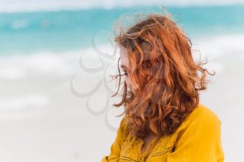 Outdoor portrait of red haired Caucasian teenage girl on the ocean coast in Dominican Republic