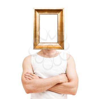 Male narcissism concept. Young sporty Caucasian man with empty golden frame over face in white shirt with crossing hands isolated on white