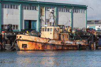Old rusty tug boat stands moored in port of Reykjavik, Iceland