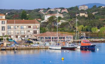 Sailing yachts and motor boats are moored in port of Porto-Vecchio town, Corsica island, France