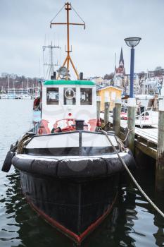 Small tug boat moored in port of Flensburg, Germany in winter season