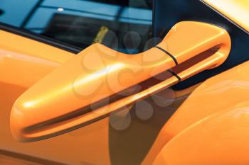 Luxury yellow sports car mirror, close-up photo