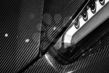 Luxury Italian sports car fragment, headlight mounted in carbon fiber body parts