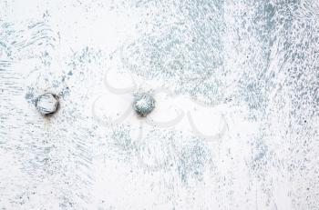 Two bolts in old metal sheet painted in white with brush spots, industrial background texture