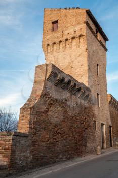 Street view with old fortress wall and tower of Fermo, Italy