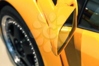 Luxury yellow sports car mirror, close up photo. Italian car design