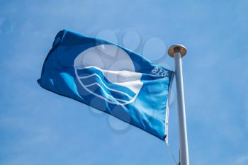 Blue Flag beach, waving flag over cloudy sky