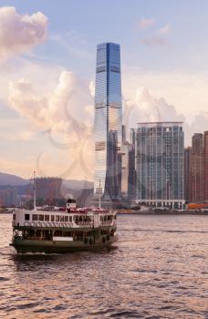 Passenger ferry goes to the International Commerce Centre of Hong Kong under colorful evening sky