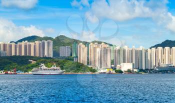 Skyline of Hong Kong city in summer day. Passenger ship moored near Yau Tong district of Hong-Kong island