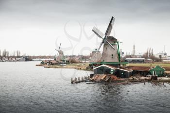 Windmills on Zaan river coast. Zaanse Schans town, Netherlands. Suburb of Amsterdam