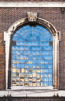 Old classic arched window in dark brick wall, London, United Kingdom