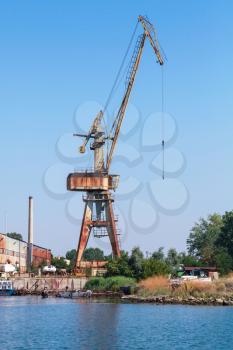 Grungy port crane stands on the Black Sea coast in Burgas port, Bulgaria
