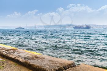 Military and cargo ships go in Bosporus strait in summer day. Istanbul, Turkey